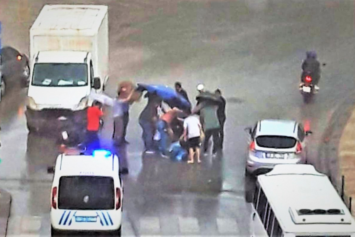 Yaralıyı korumak için ellerindeki şemsiyelerle fırtınaya direndiler